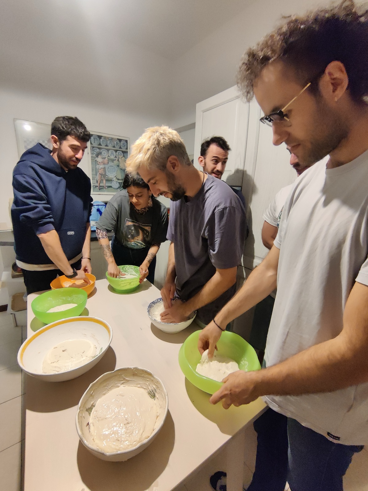 People mixing pizza dough together around a kitchen table during the Slowlit pilot