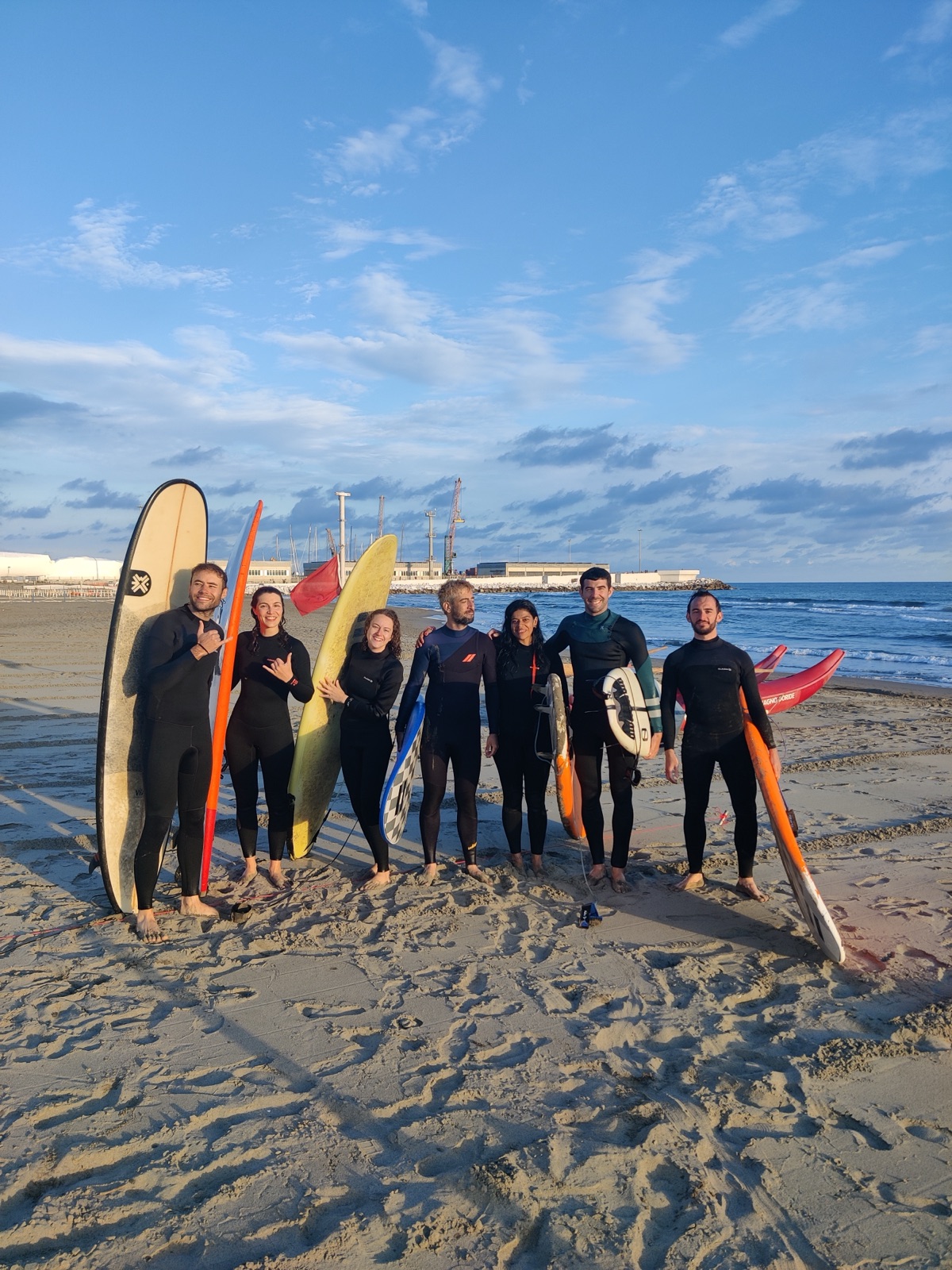 People standing with surfboards on the beach after surfing during the Slowlit pilot